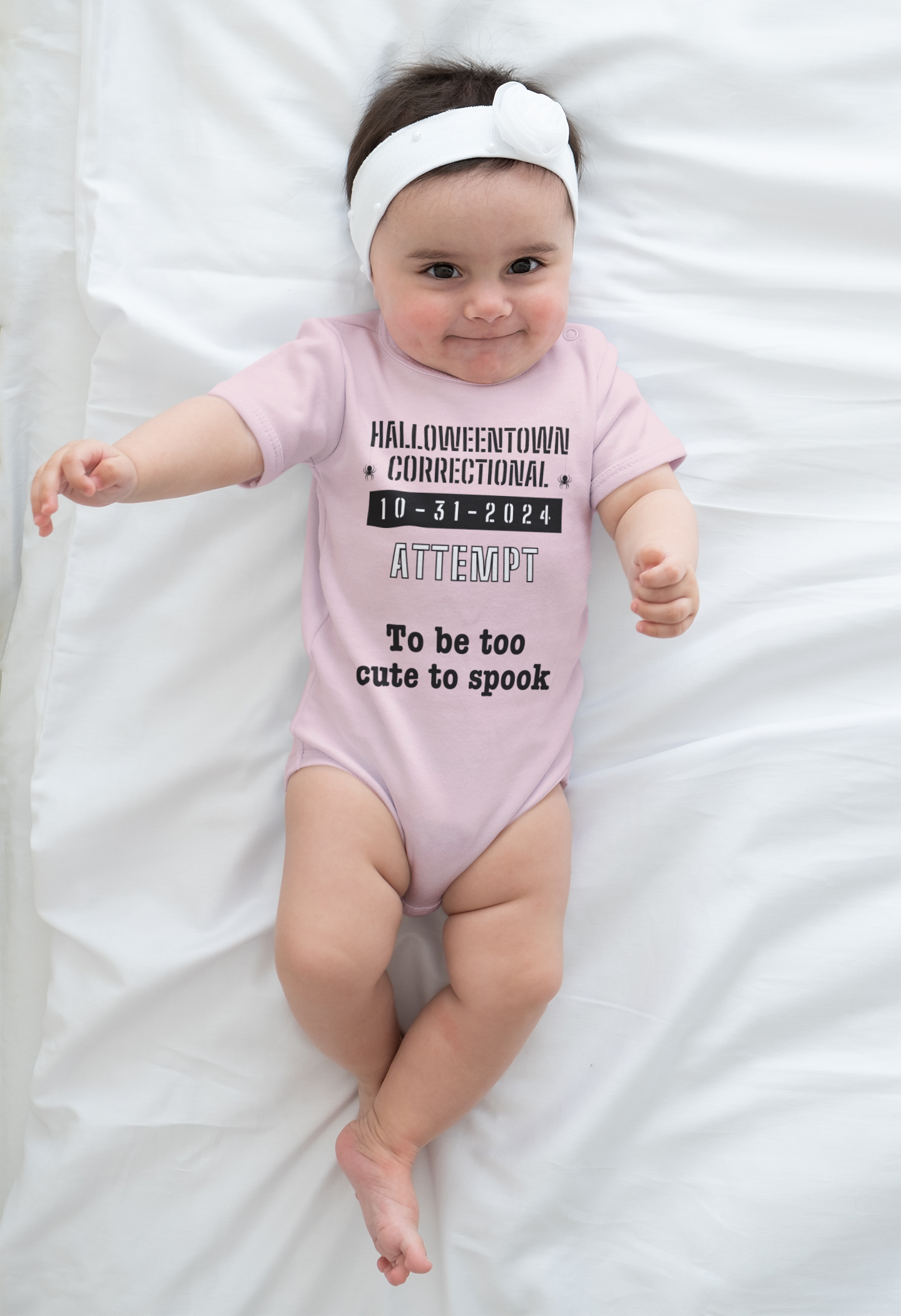 baby girl wearing a pink onesie that says halloweentown correctional attempt to be too cute to spook family costume