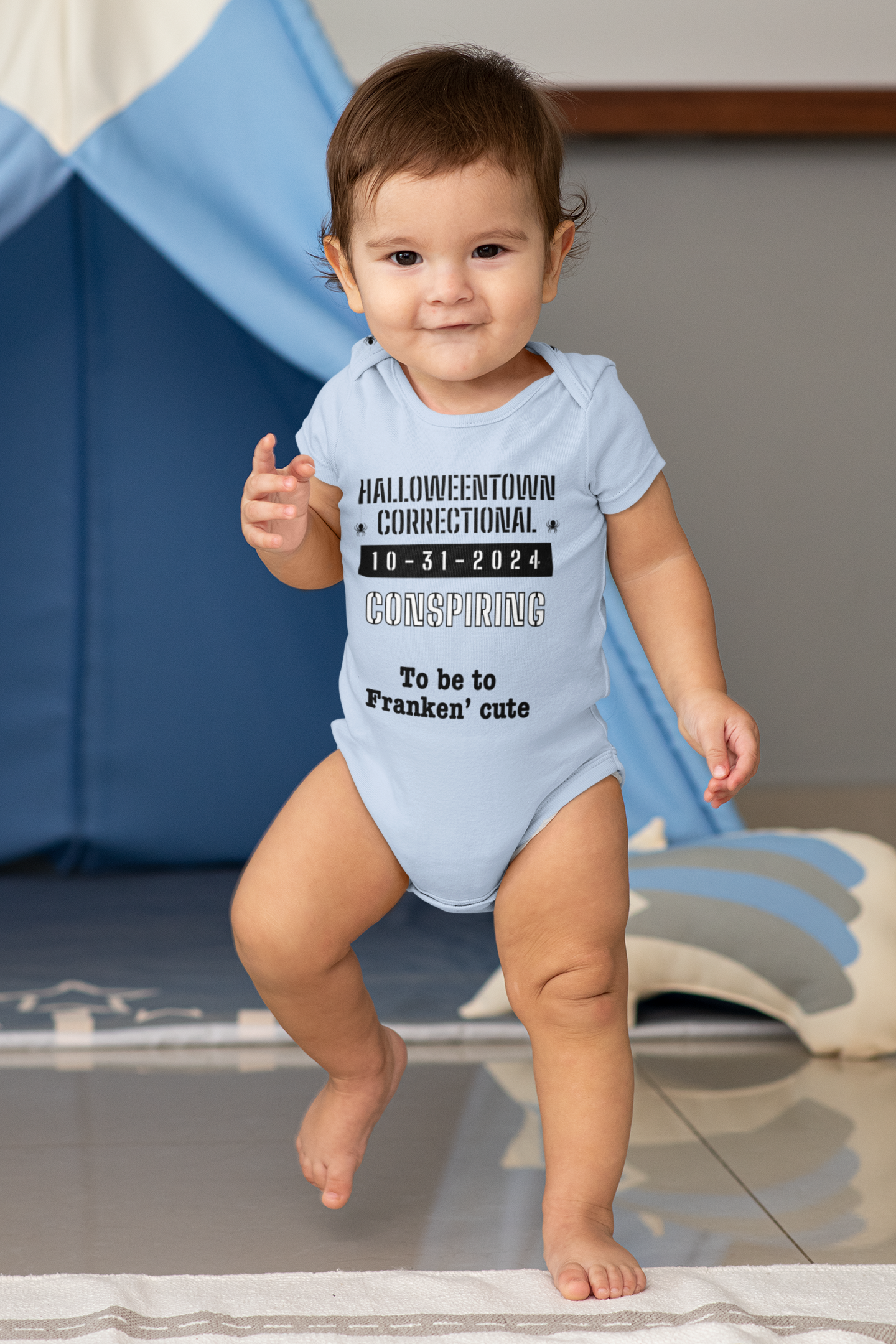 baby boy wearing a blue onesie that says halloweentown correctional conspiring to be too franken' cute family costume