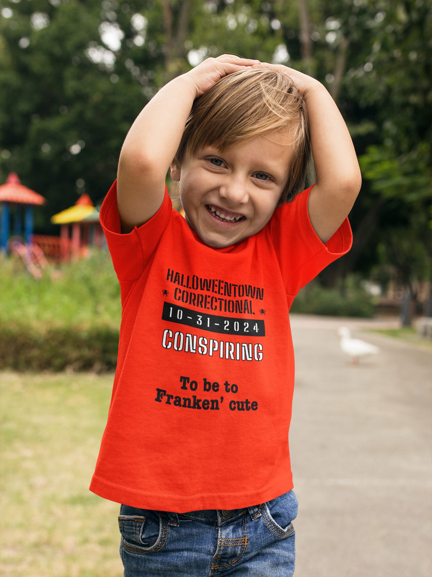 little boy wearing an orange shirt that says HalloweenTown correctional conspiring to be too franken' cute family costume
