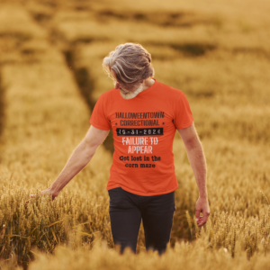 man in field wearing a shirt that says halloweentown correctional failure to appear got lost in a corn maze family costume