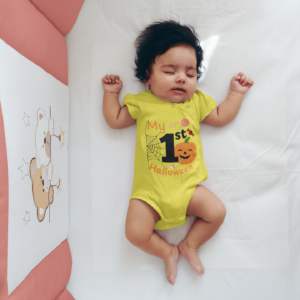baby wearing a yellow onesie that says my 1st halloween with pumpkins etc